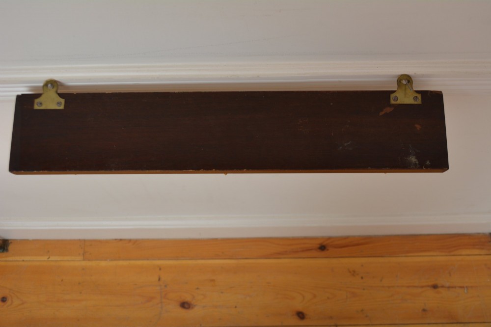 A rectangular polished mahogany backboard mounted with three polished brass double coat hooks featuring diamond-shaped backplates. View III