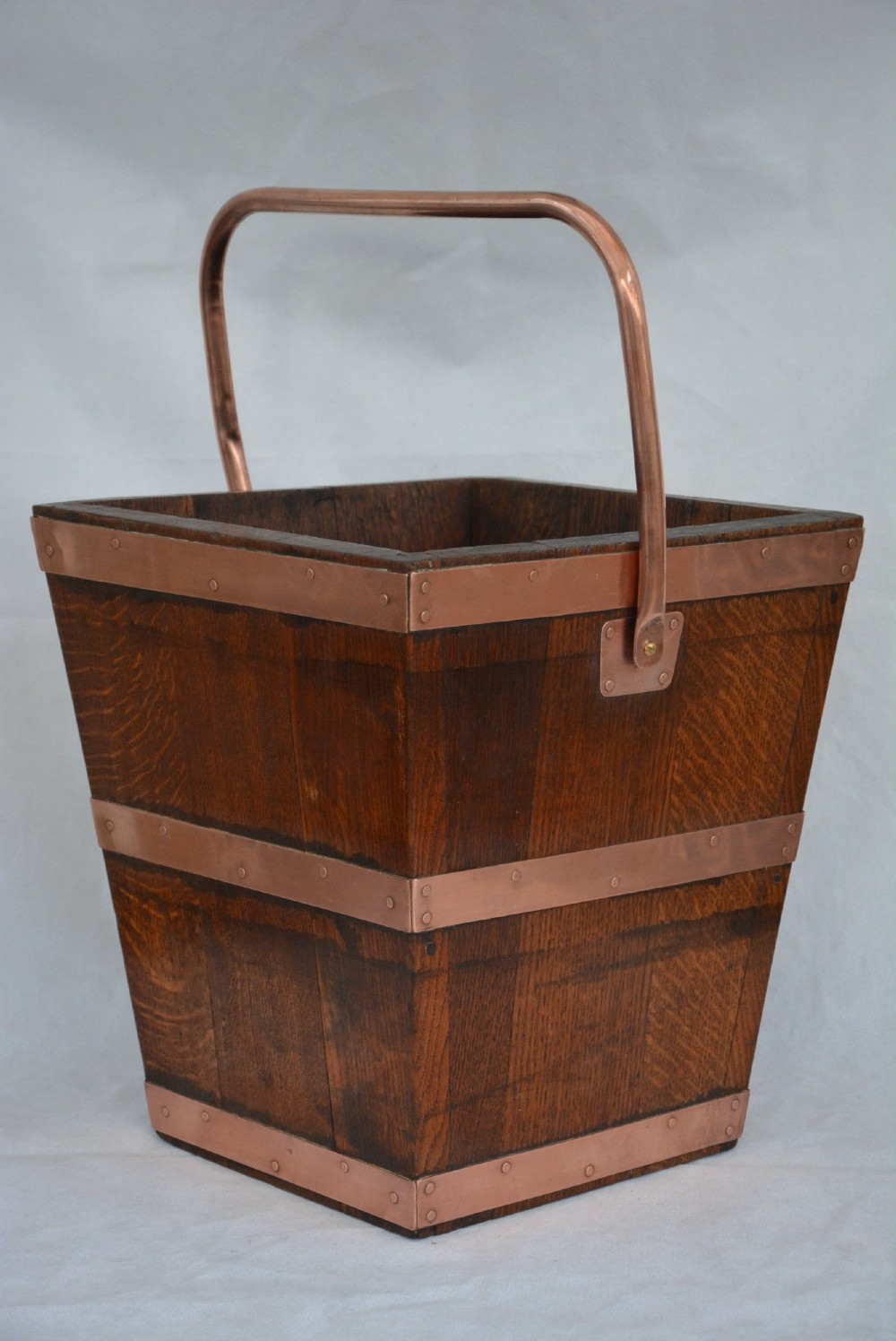 A tapered dark oak wooden coal bucket bound with copper straps and featuring a copper swing handle. View II