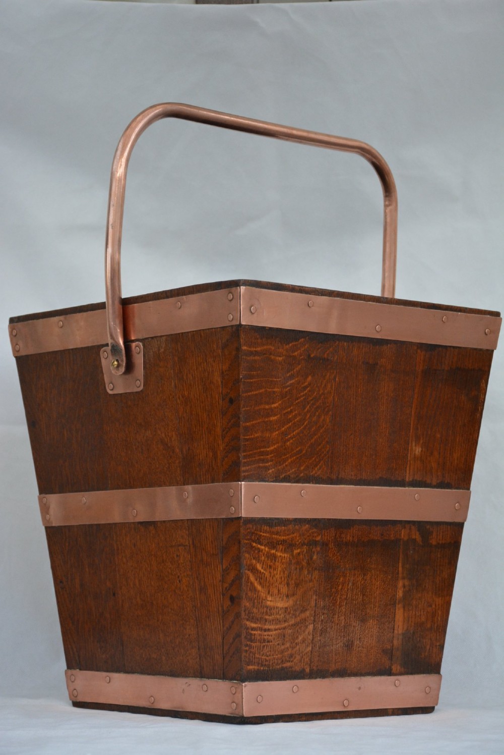 A tapered dark oak wooden coal bucket bound with copper straps and featuring a copper swing handle. View IV