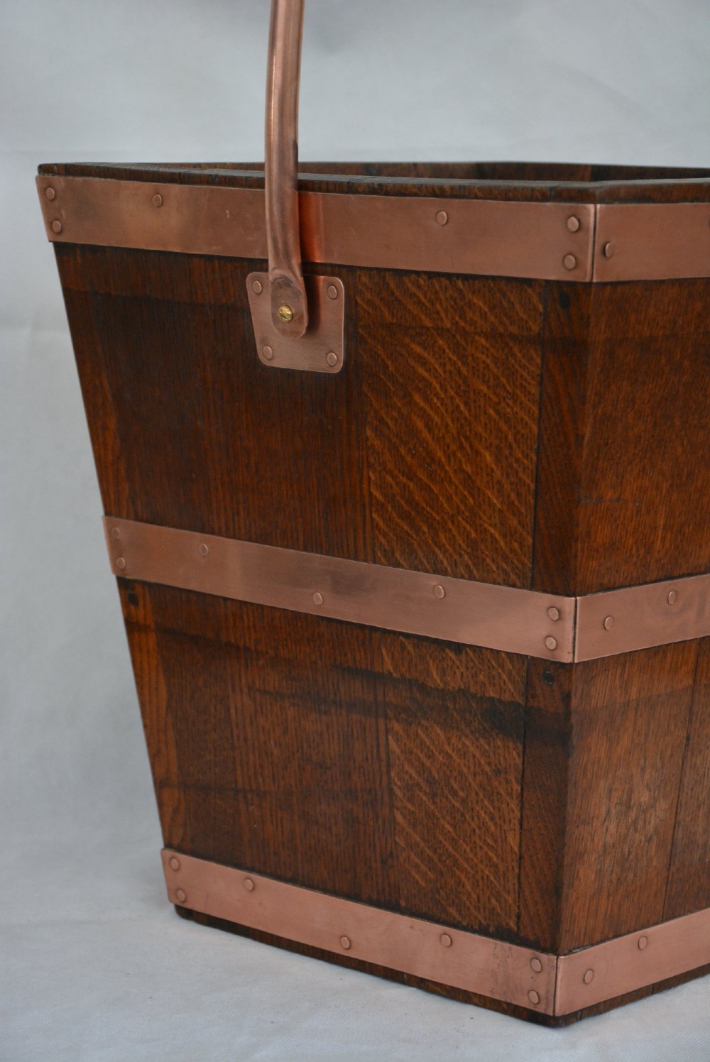 A tapered dark oak wooden coal bucket bound with copper straps and featuring a copper swing handle. View VII