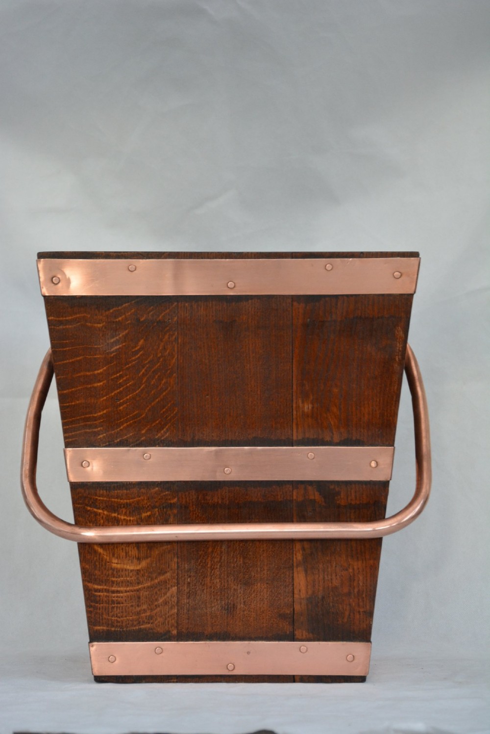 A tapered dark oak wooden coal bucket bound with copper straps and featuring a copper swing handle. View IX