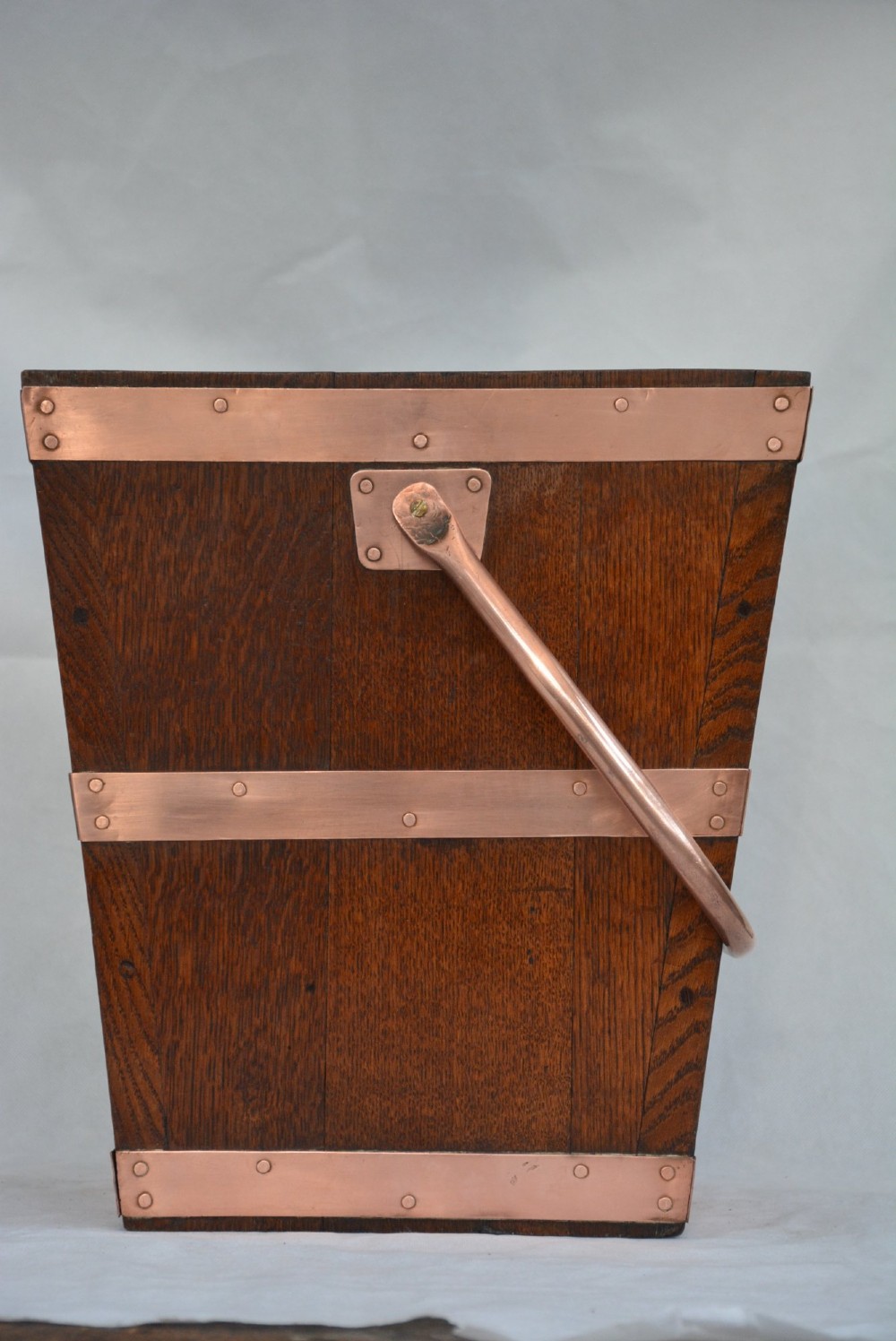 A tapered dark oak wooden coal bucket bound with copper straps and featuring a copper swing handle. View X