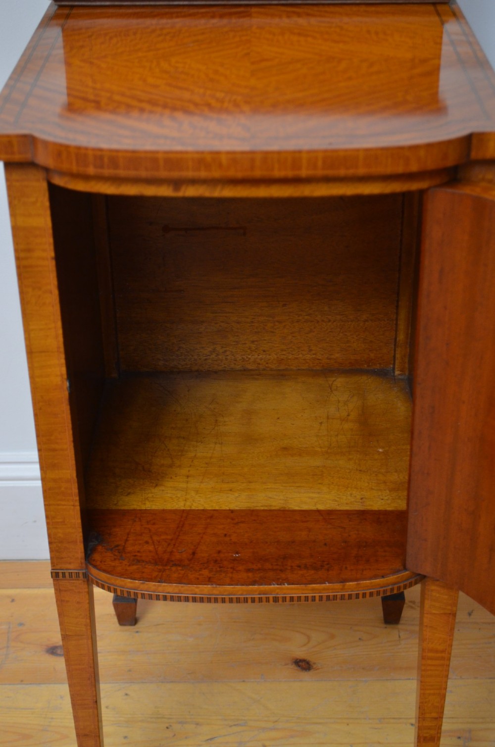 An Edwardian satinwood bedside cabinet with a gallery upstand top, diamond-patterned veneered cupboard door, and square tapered legs. View X