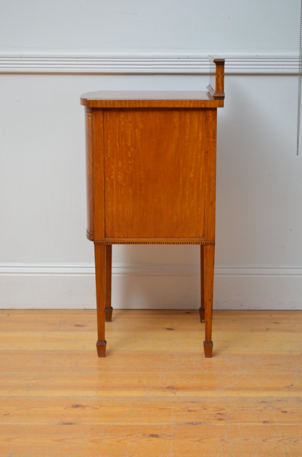 An Edwardian satinwood bedside cabinet with a gallery upstand top, diamond-patterned veneered cupboard door, and square tapered legs. View XIII