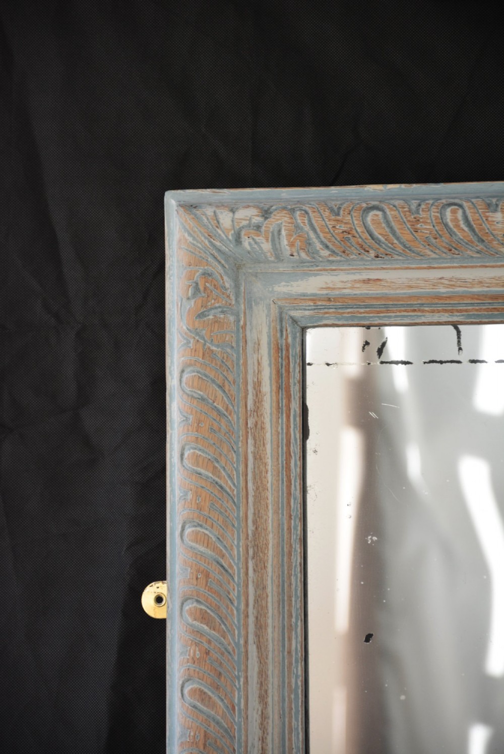 A tall rectangular wall or floor mirror featuring a relief-carved oak frame with a grey-washed finish and brass side brackets. View III