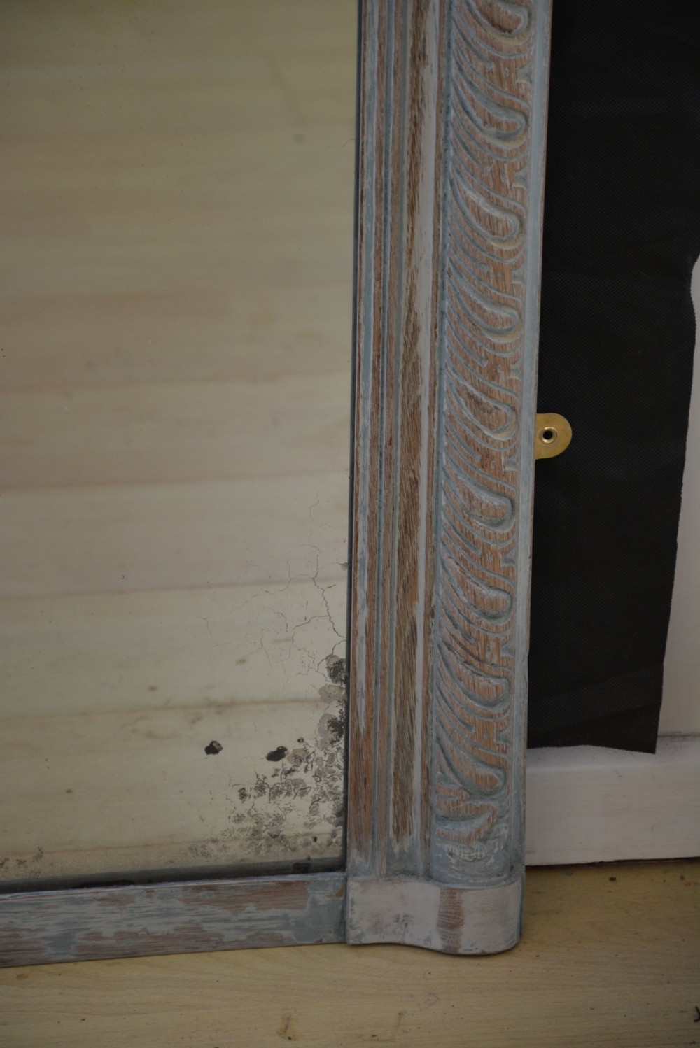 A tall rectangular wall or floor mirror featuring a relief-carved oak frame with a grey-washed finish and brass side brackets. View IX