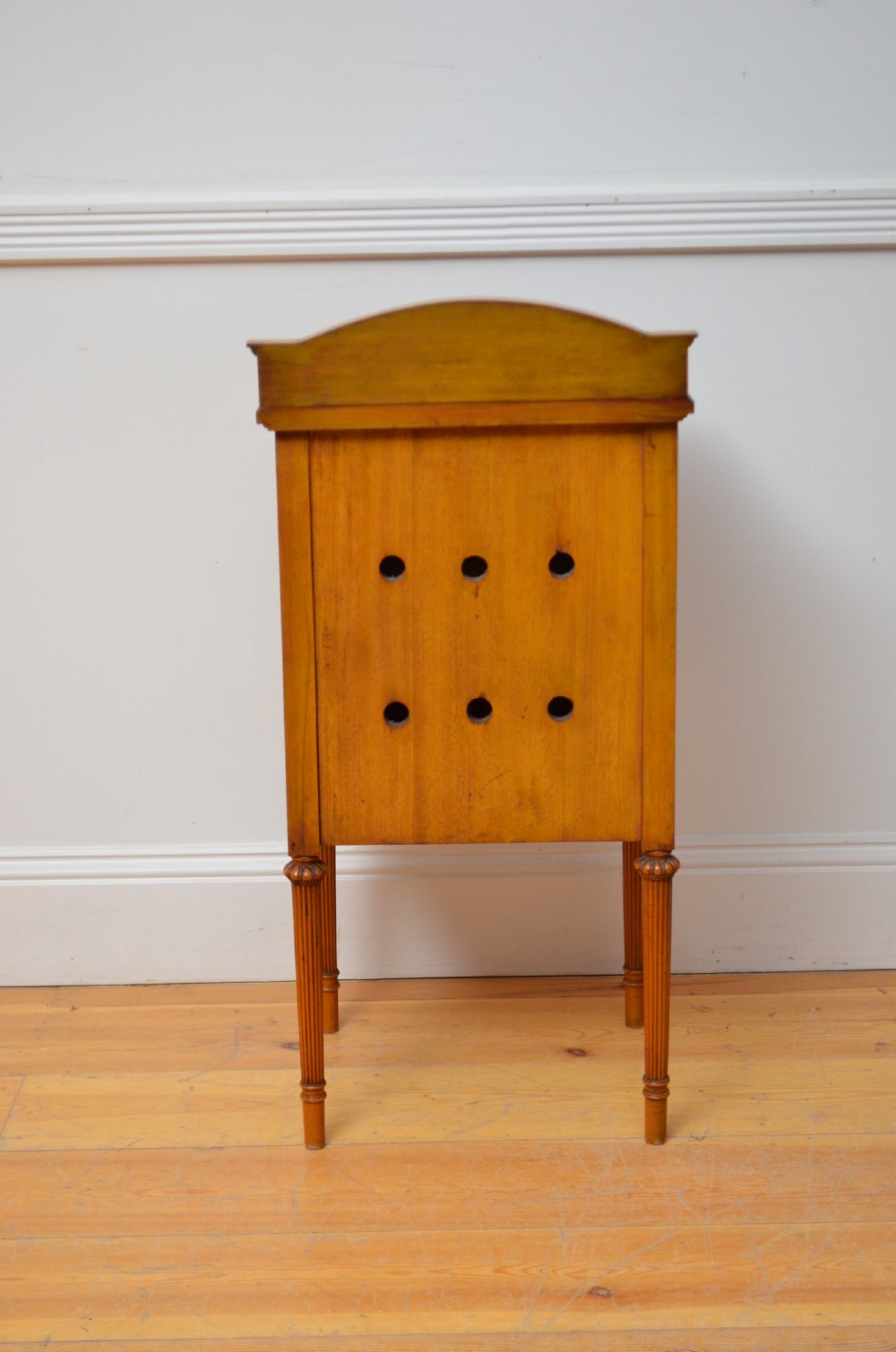 An Edwardian satinwood bedside cupboard featuring chevron veneer detailing, an upper drawer, a lower door, and turned reeded legs. View IX