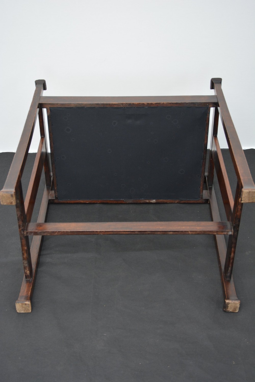 An antique dark mahogany Arts and Crafts stool featuring upright corner posts with square finials, vertical side splats, and a pattern-upholstered fabric seat. View IX
