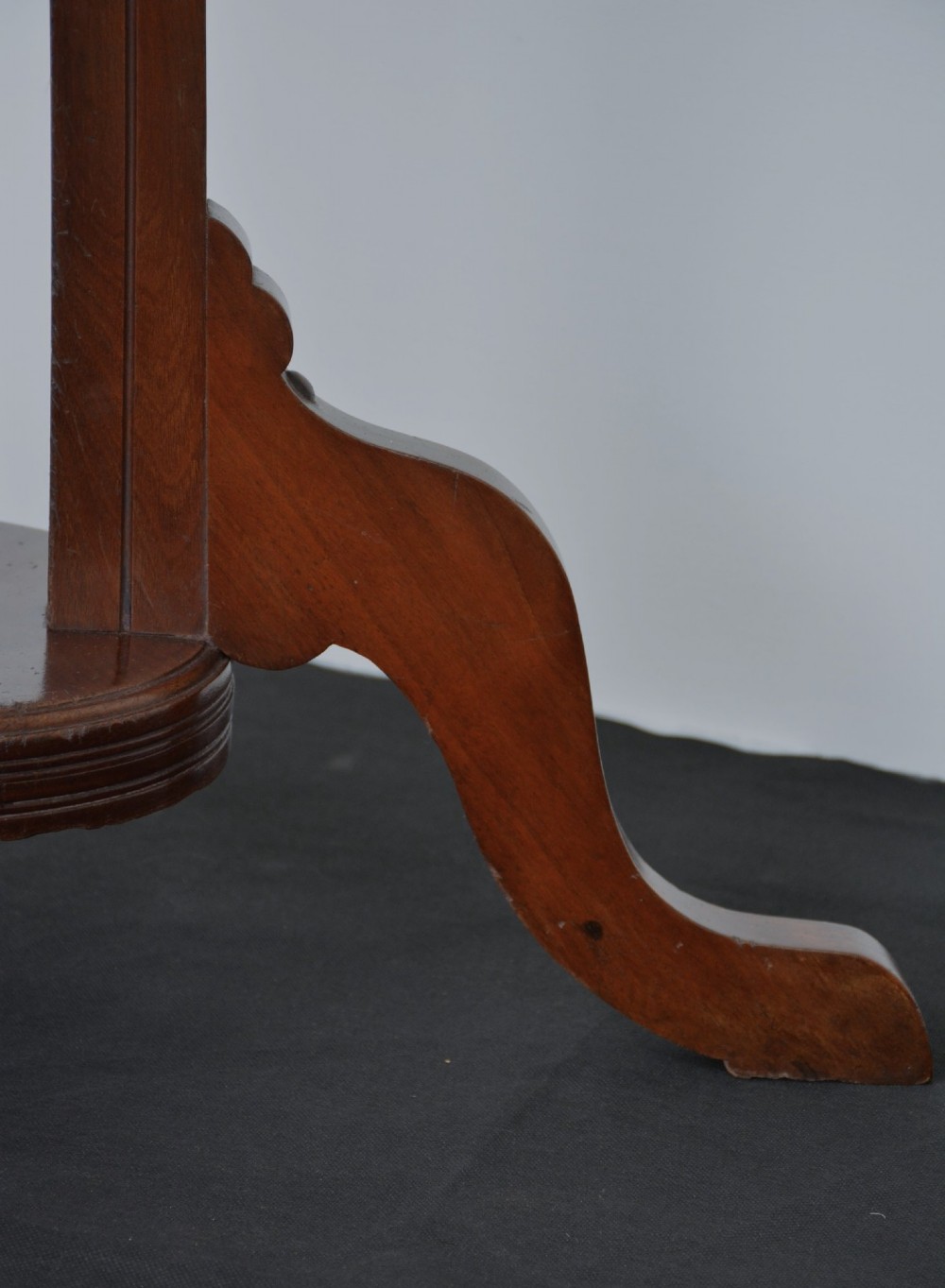 A tall freestanding dark walnut coat stand featuring a slatted central column, brass hooks, a turned finial, and four splayed feet. View III