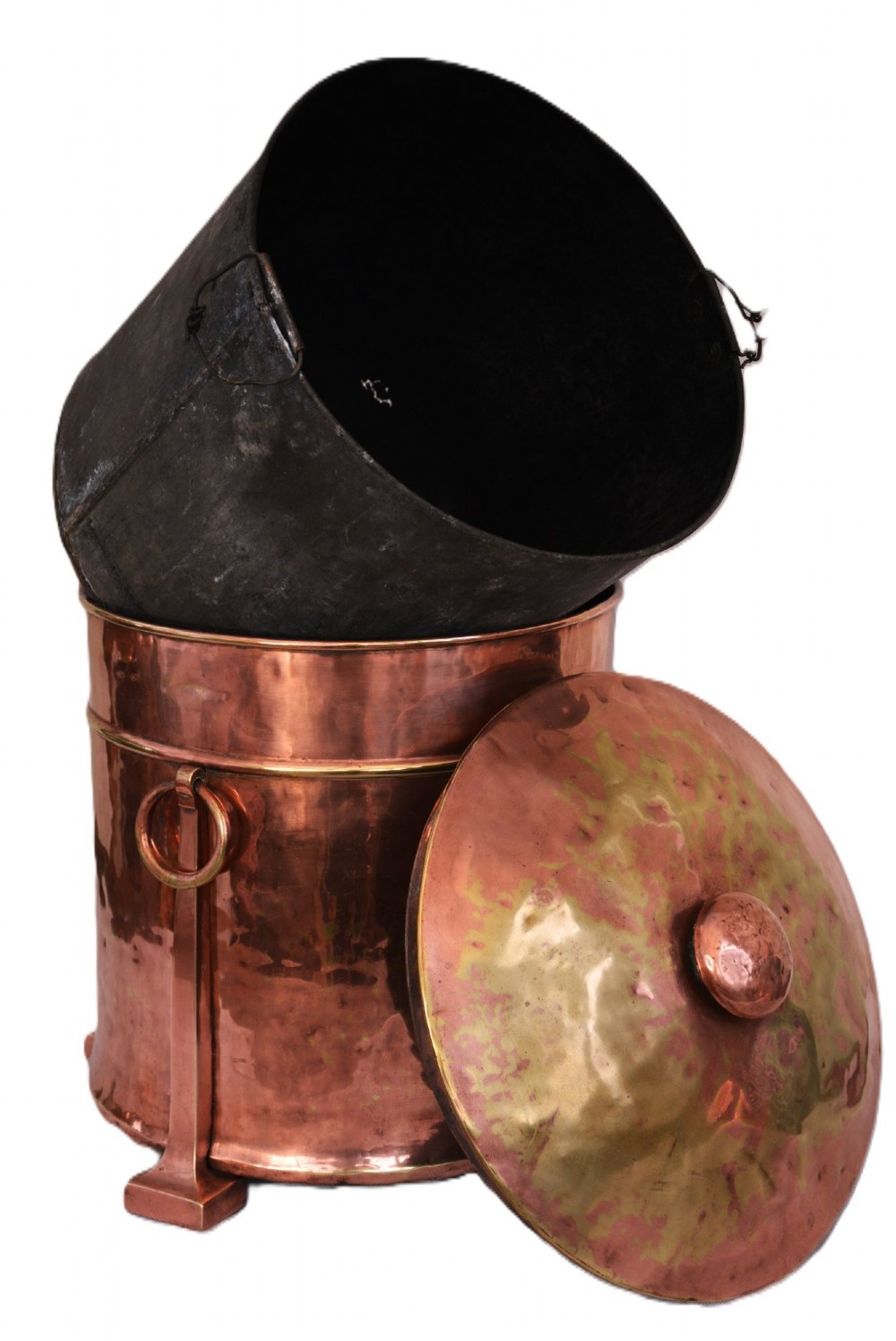 An Arts and Crafts hammered copper cylindrical coal bin featuring a fitted lid, drop side ring handles, structural legs, and a removable metal liner.