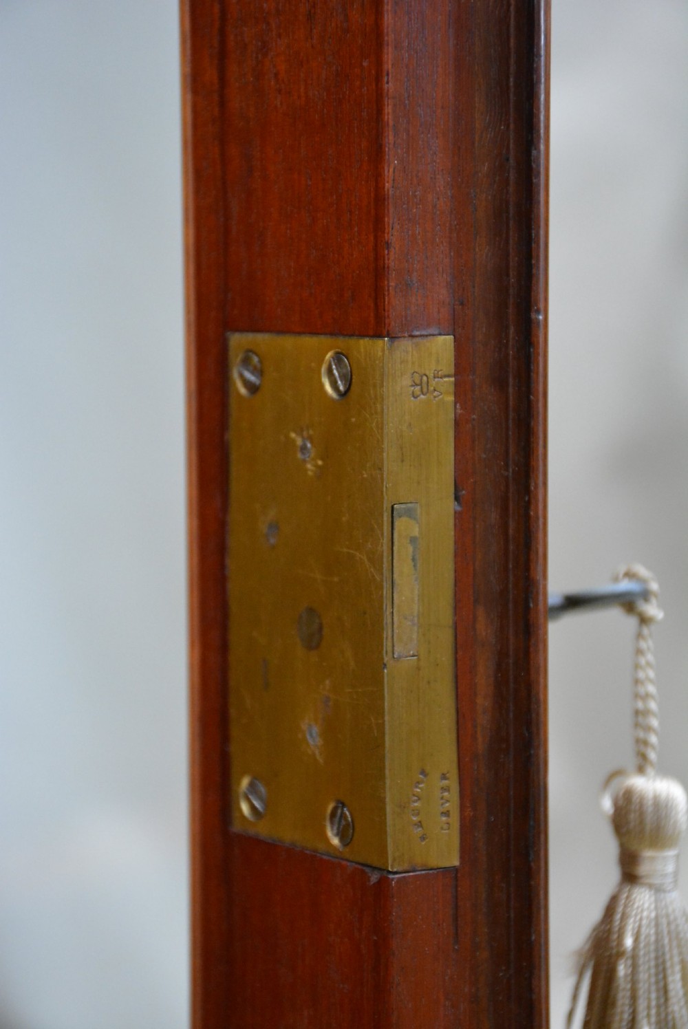 An English Victorian low bookcase made of figured walnut with two arched glass doors, carved corbels, and internal shelves. View II