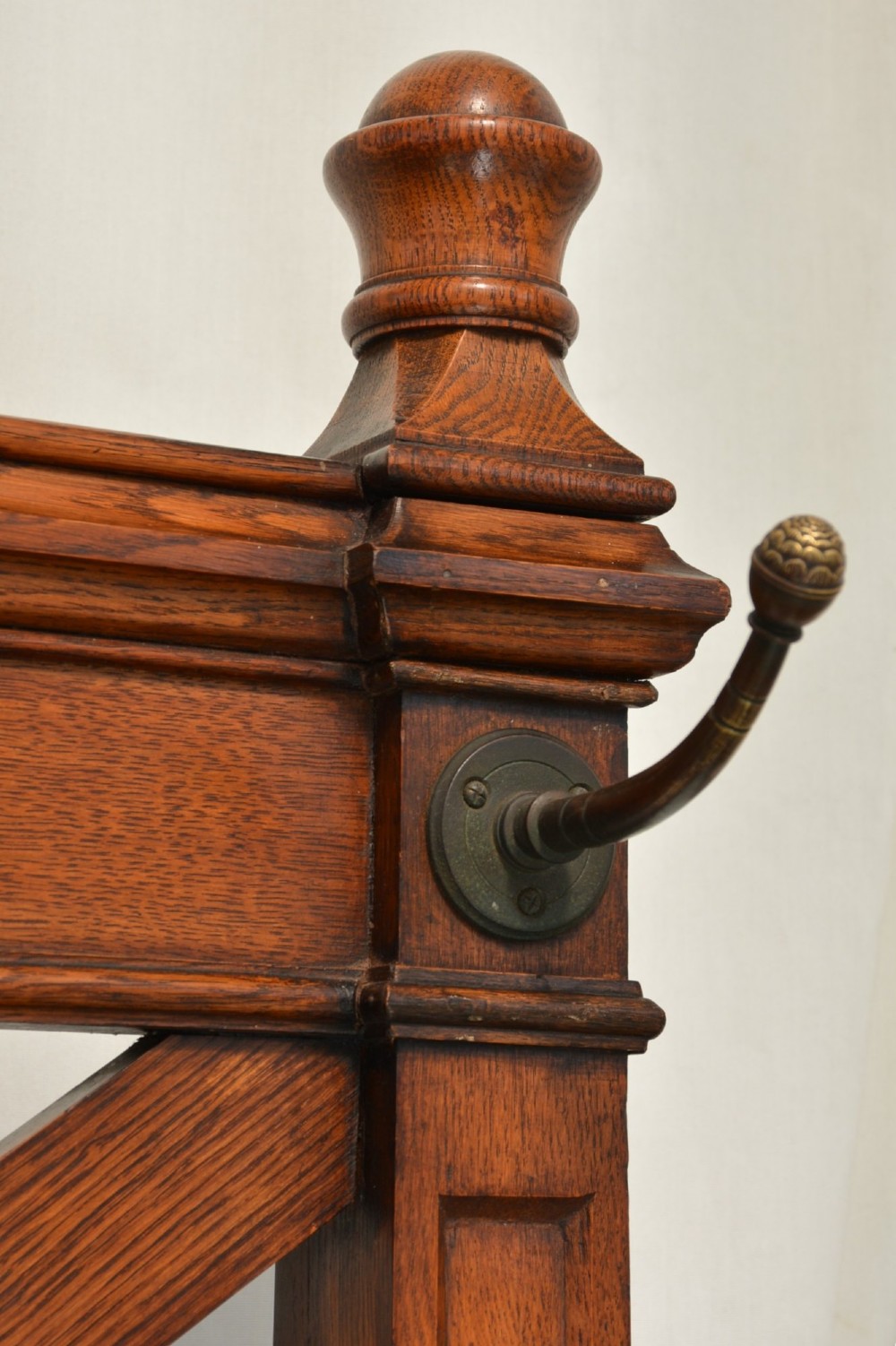 A tall Victorian Gothic oak hall stand featuring cross-braced lattice framing, metal coat pegs, finial tops, and carved architectural supports. View XI