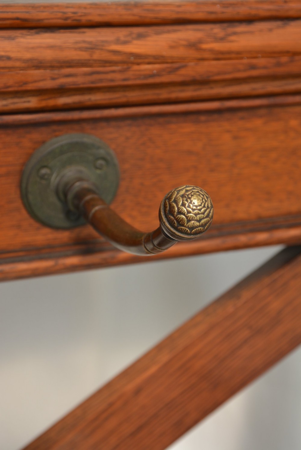 A tall Victorian Gothic oak hall stand featuring cross-braced lattice framing, metal coat pegs, finial tops, and carved architectural supports. View XII