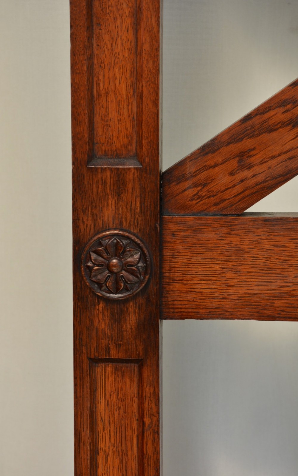 A tall Victorian Gothic oak hall stand featuring cross-braced lattice framing, metal coat pegs, finial tops, and carved architectural supports. View XIII