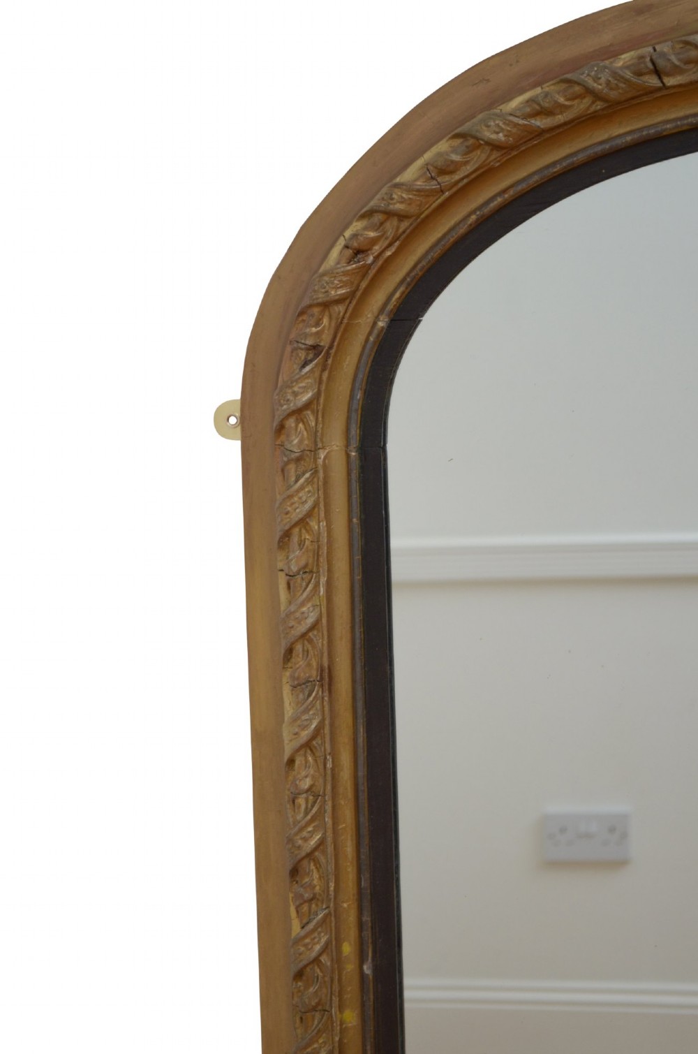 A tall arched overmantel mirror featuring a gold gilded frame decorated with an intricate carved top cresting and scroll base feet. View IV
