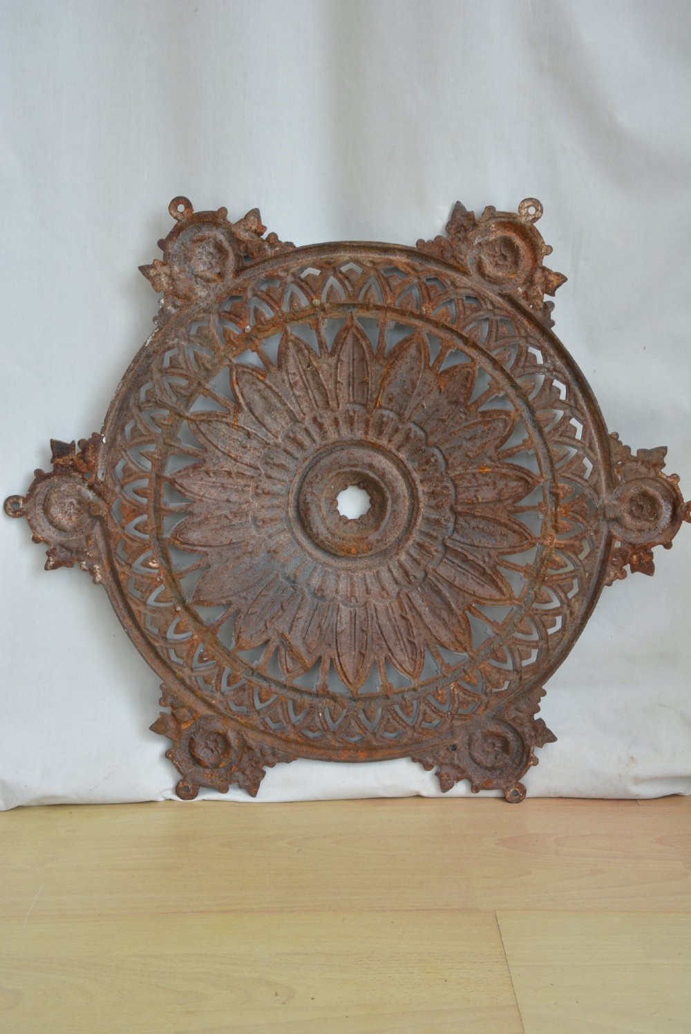A circular Victorian cast iron ceiling rose featuring central feather relief detail surrounded by pierced openwork and ivy leaf border lugs. View II