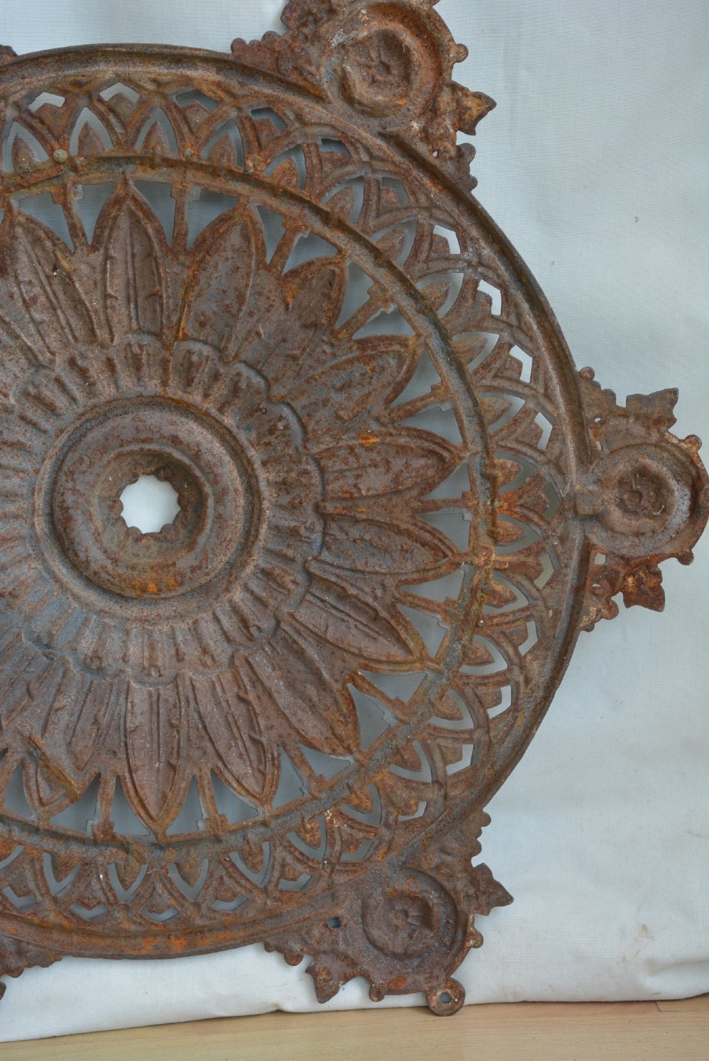 A circular Victorian cast iron ceiling rose featuring central feather relief detail surrounded by pierced openwork and ivy leaf border lugs. View III