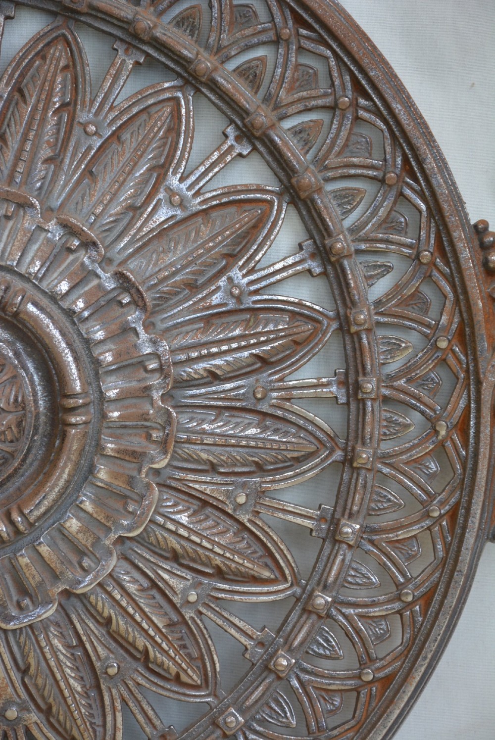 A circular Victorian cast iron ceiling rose featuring central feather relief detail surrounded by pierced openwork and ivy leaf border lugs. View XIII