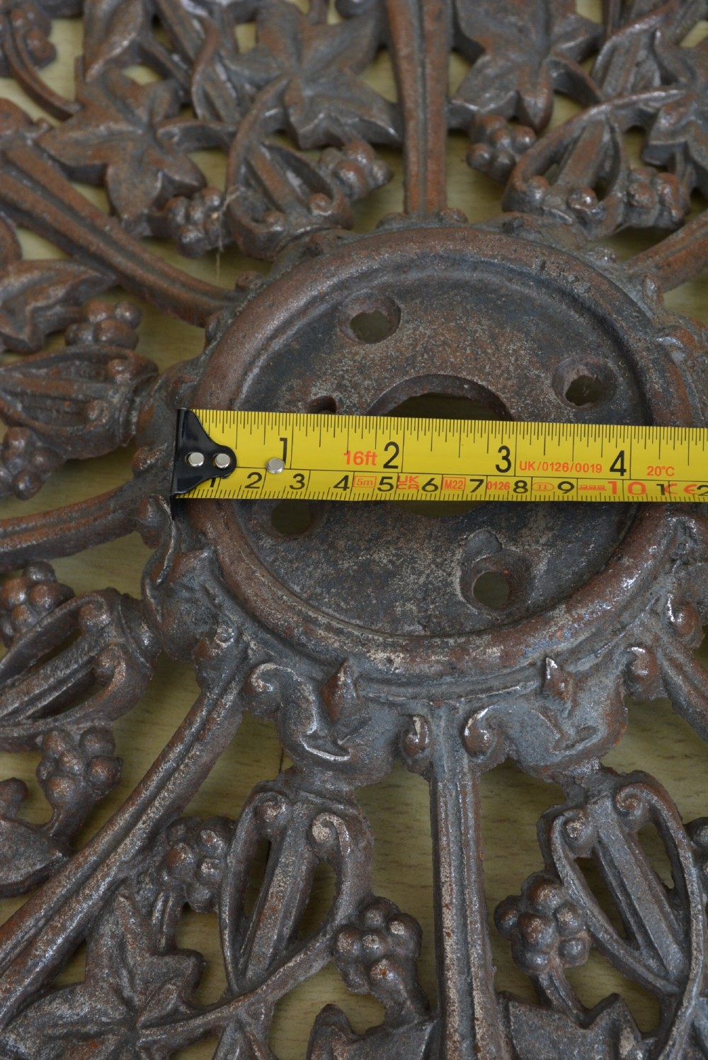 A circular Victorian cast iron ceiling rose featuring an openwork lobed design with raised ivy leaf and berry motifs surrounding a central circular aperture. View XIV