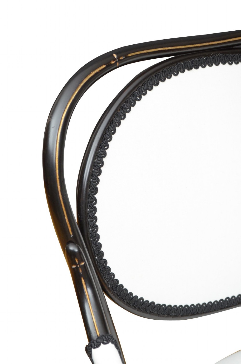 An ebonised bentwood armchair featuring white upholstered seat and back panels, scrolled armrests, and gold linear detailing on a black wooden frame. View VII