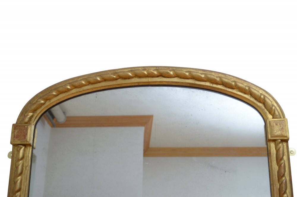 A tall nineteenth-century arched mirror featuring a gilded frame with a continuous carved rope twist motif. View VII
