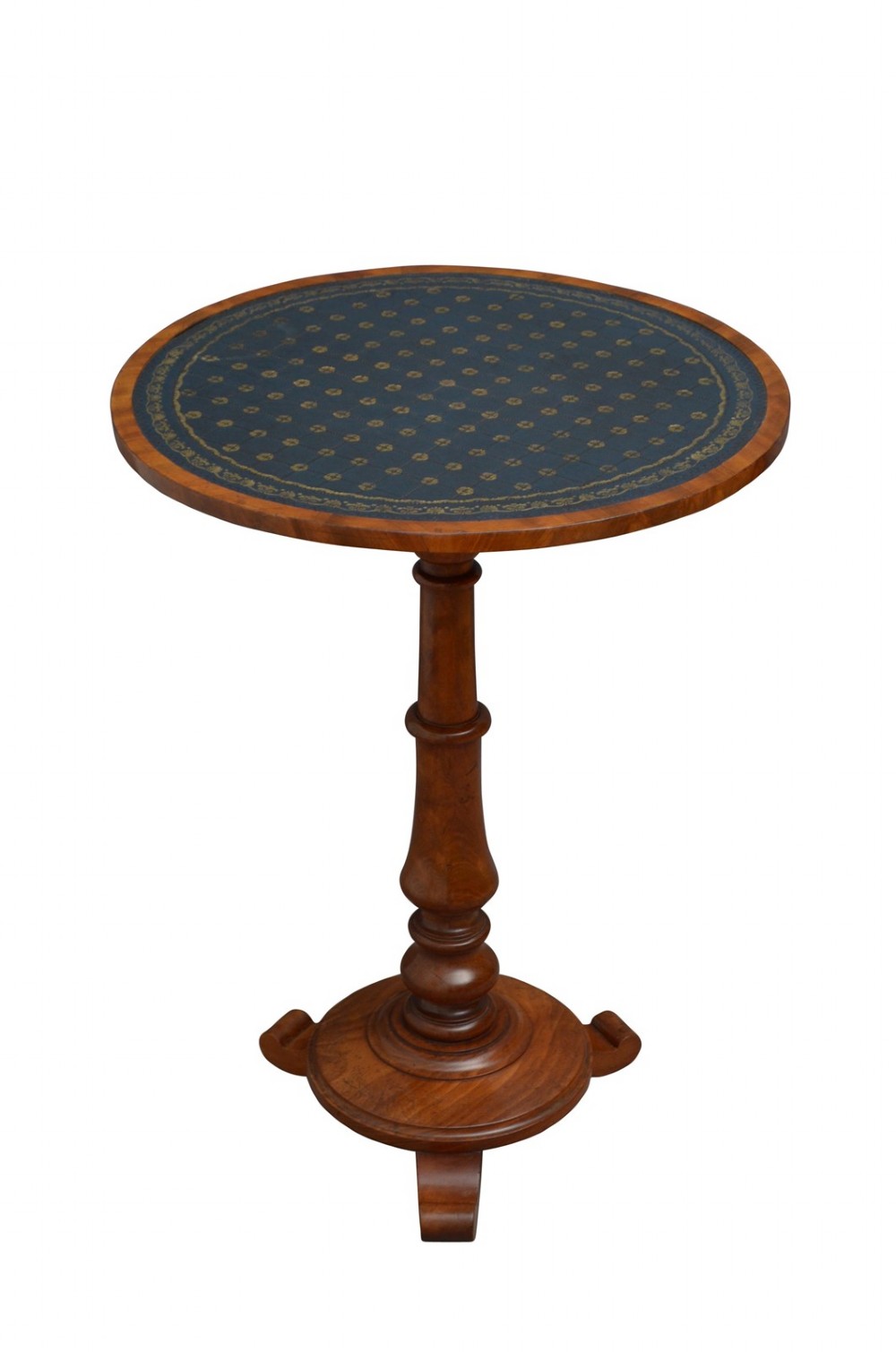A William IV mahogany circular lamp table featuring a dark blue gilt-tooled leather inset top supported by a turned pedestal stem on a tri-form scroll-foot base.