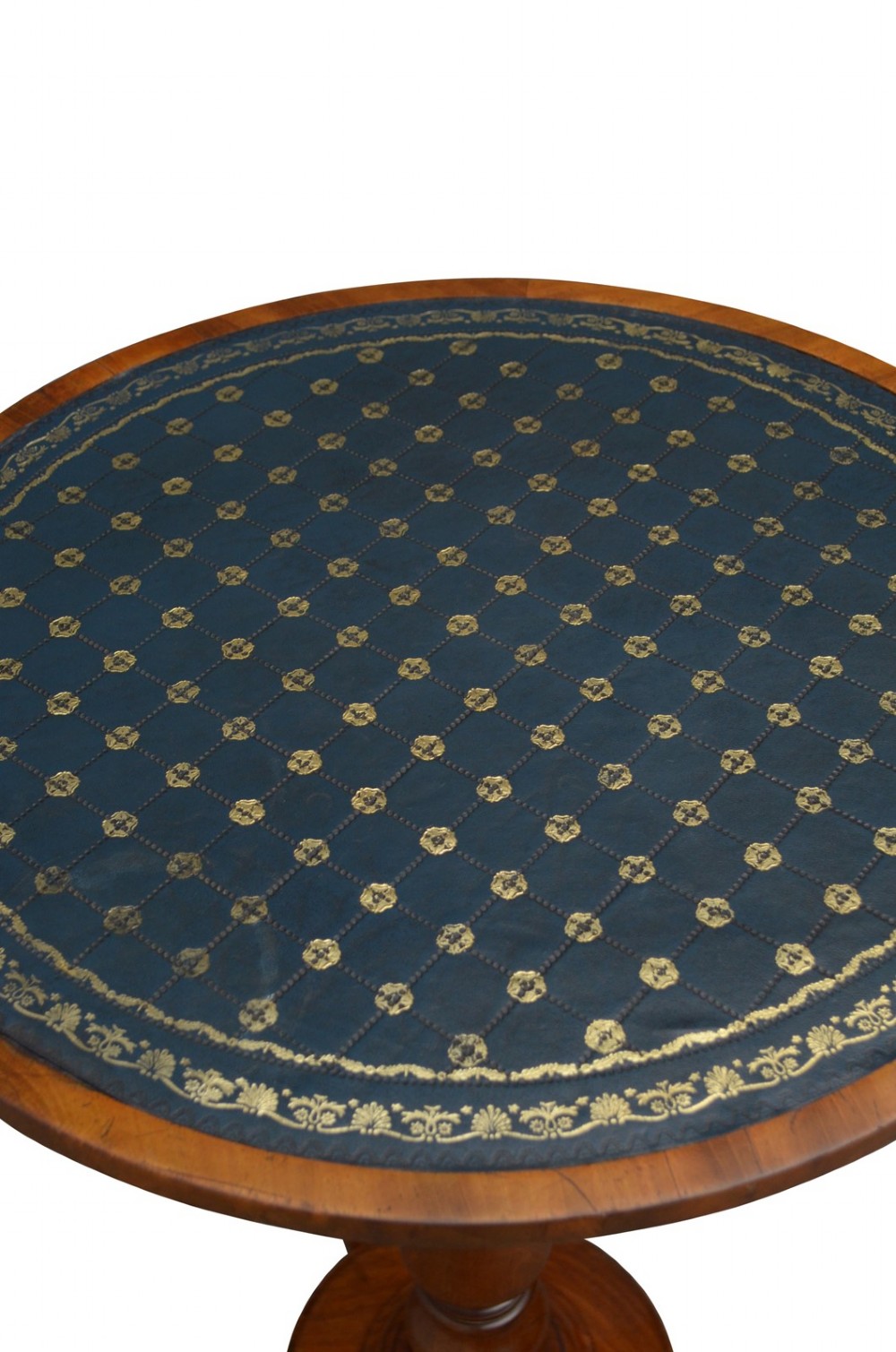 A William IV mahogany circular lamp table featuring a dark blue gilt-tooled leather inset top supported by a turned pedestal stem on a tri-form scroll-foot base. View V