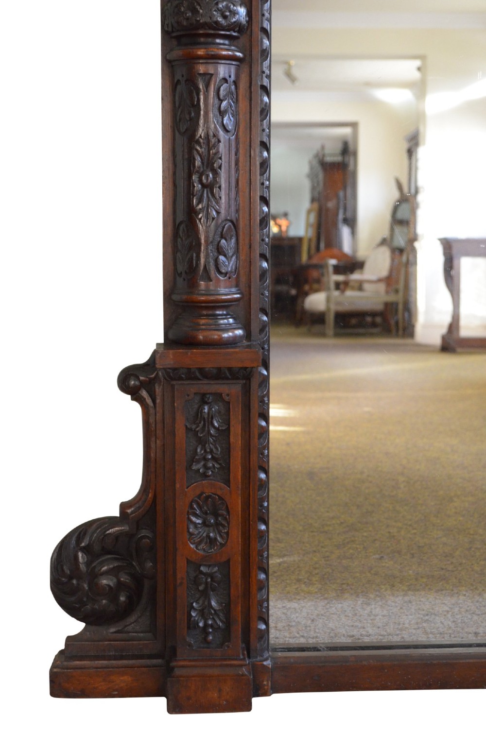 A tall 19th-century English solid oak mirror featuring an arched top, fluted column sides, and detailed hand-carved woodwork. View VI