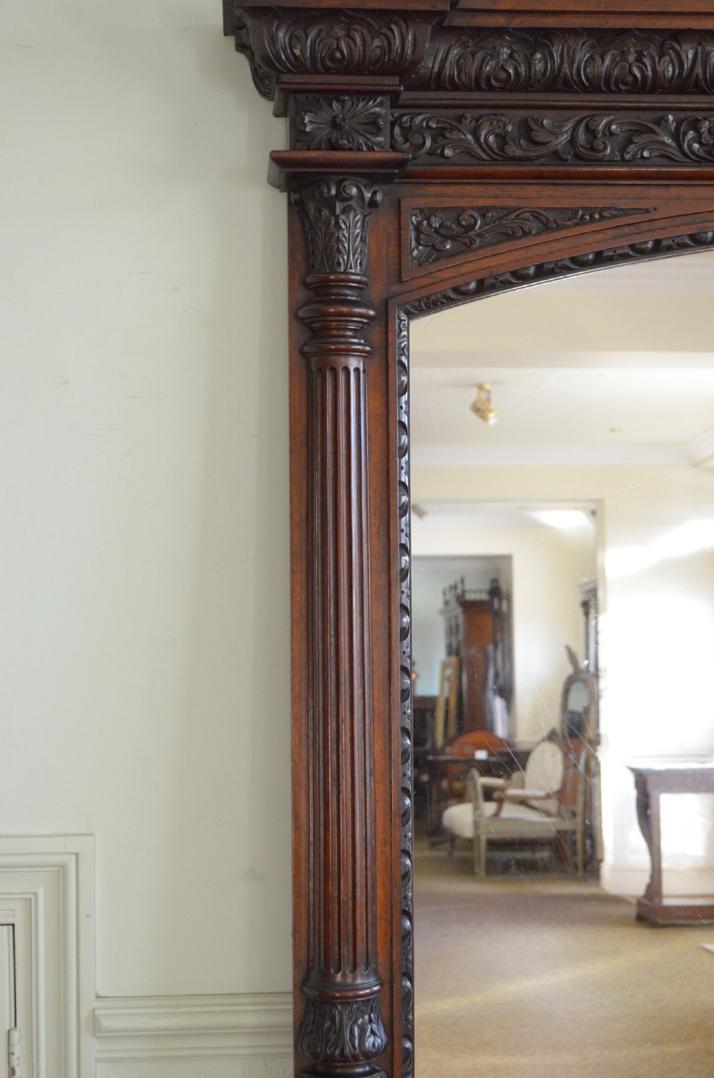 A tall 19th-century English solid oak mirror featuring an arched top, fluted column sides, and detailed hand-carved woodwork. View VIII