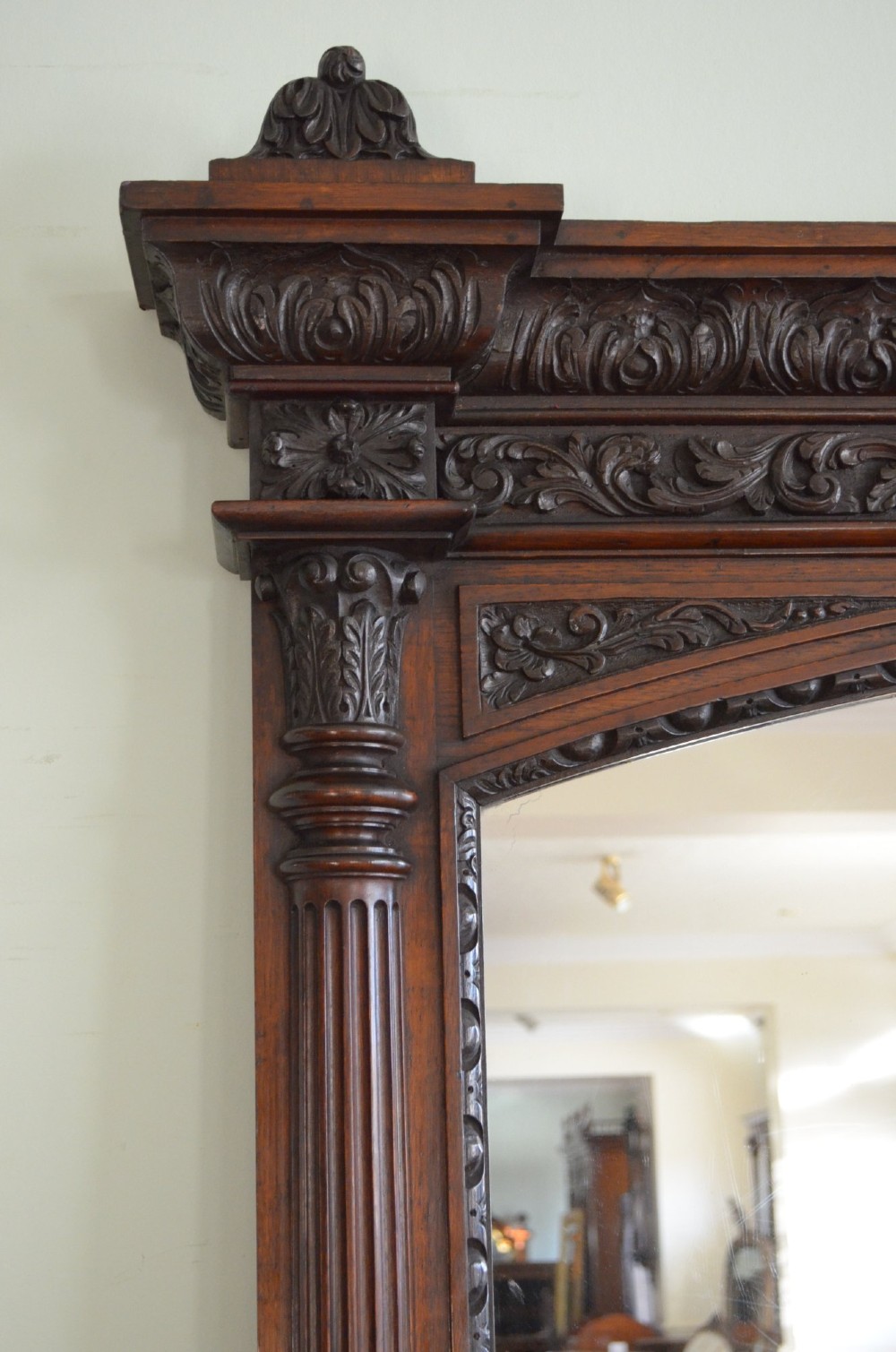 A tall 19th-century English solid oak mirror featuring an arched top, fluted column sides, and detailed hand-carved woodwork. View IX