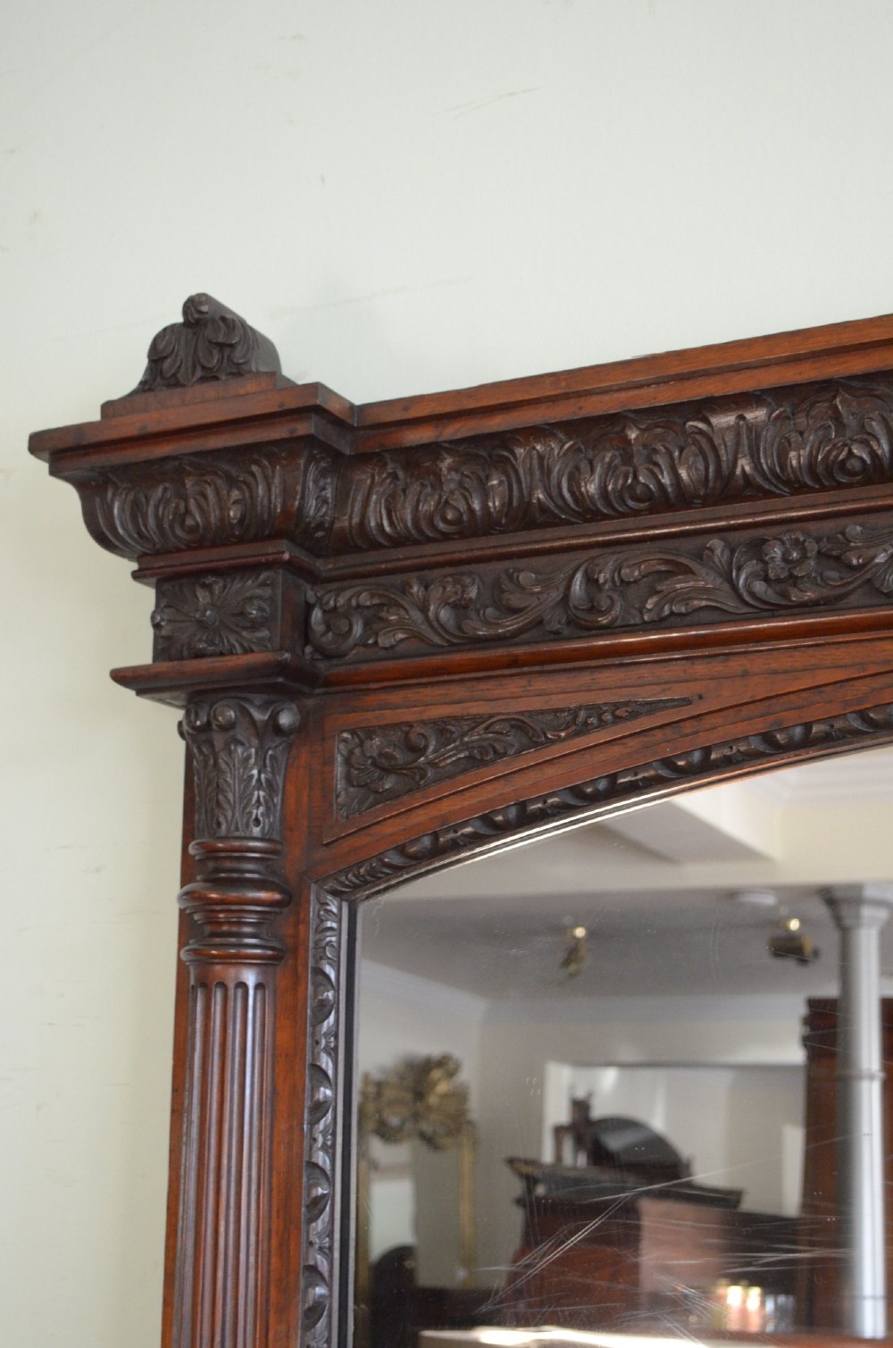 A tall 19th-century English solid oak mirror featuring an arched top, fluted column sides, and detailed hand-carved woodwork. View X