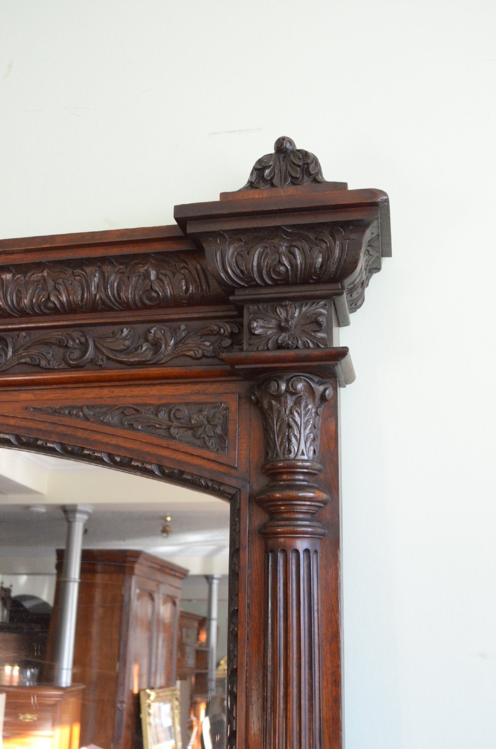 A tall 19th-century English solid oak mirror featuring an arched top, fluted column sides, and detailed hand-carved woodwork. View XIII