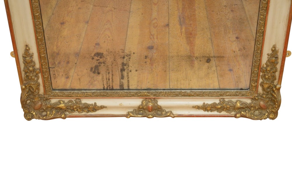 A rectangular 19th-century French Rococo wall mirror featuring an off-white frame decorated with ornate gold gilt gesso scrollwork and corner cartouches surrounding an aged glass plate. View VI