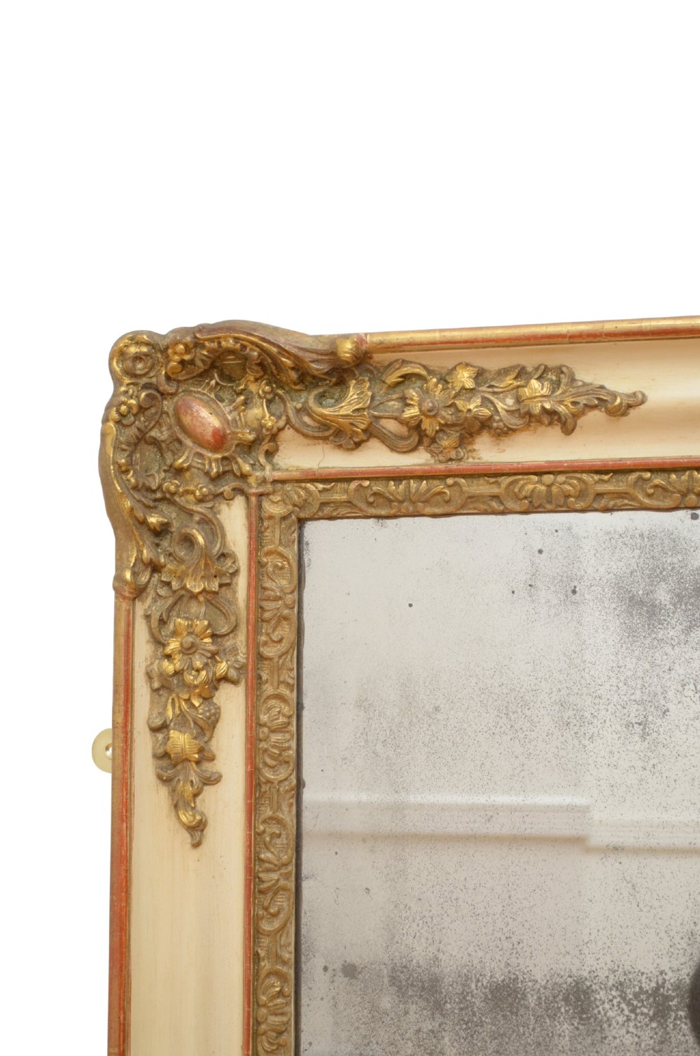 A rectangular 19th-century French Rococo wall mirror featuring an off-white frame decorated with ornate gold gilt gesso scrollwork and corner cartouches surrounding an aged glass plate. View IX