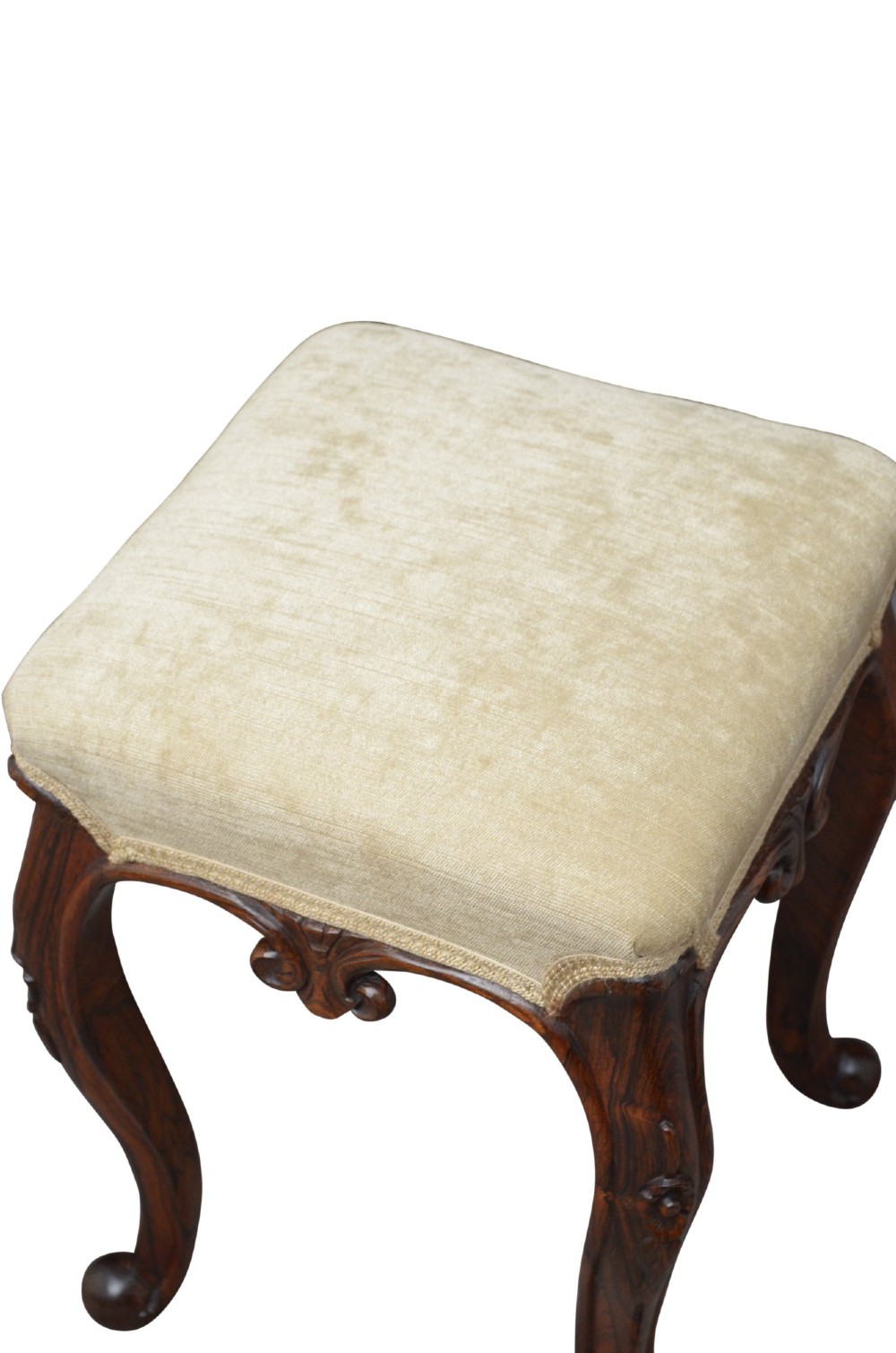 A nineteenth-century Victorian dressing table stool crafted from dark Goncalo Alves wood featuring carved cabriole legs and a cream upholstered padded top. View IV