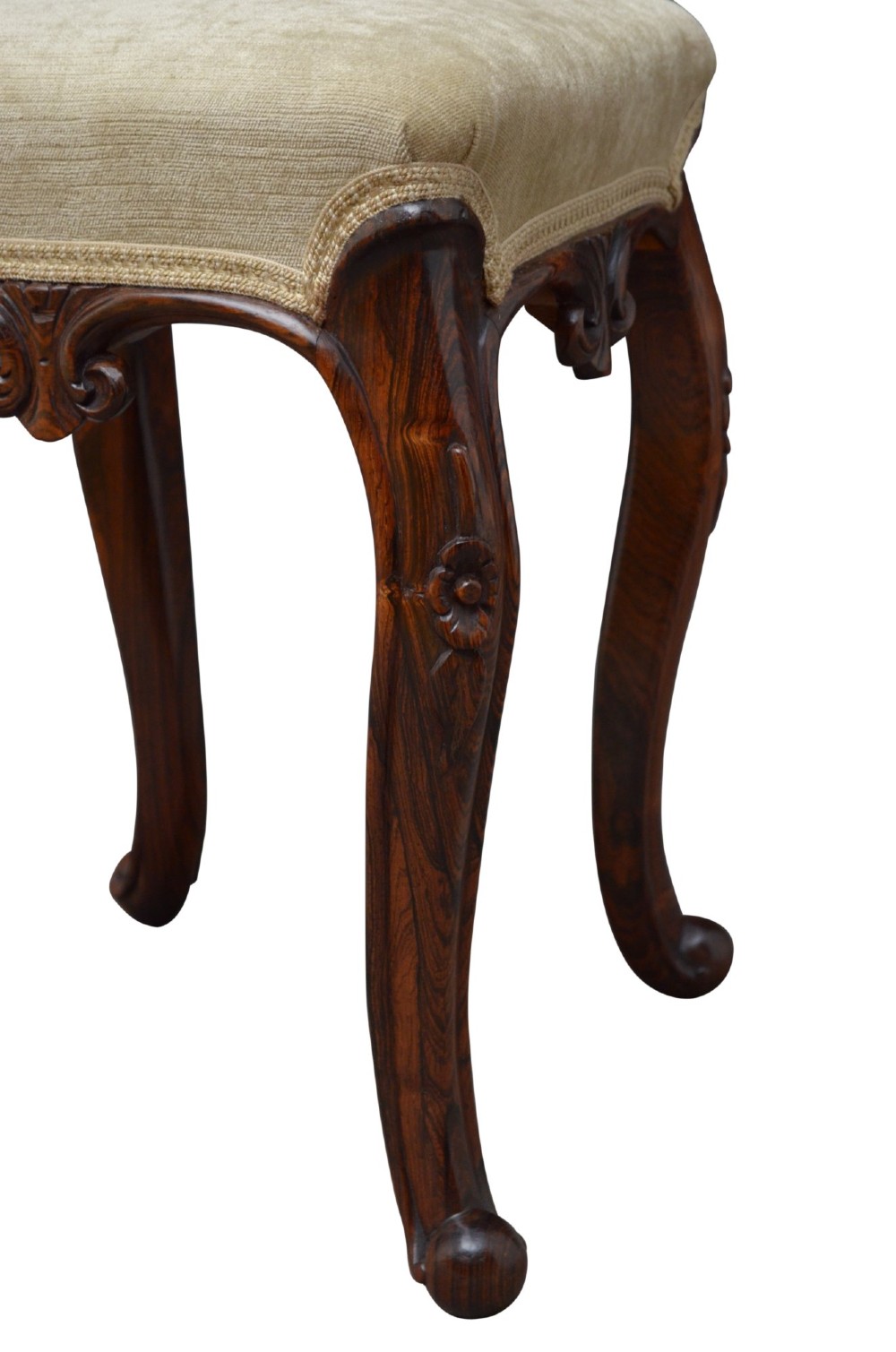 A nineteenth-century Victorian dressing table stool crafted from dark Goncalo Alves wood featuring carved cabriole legs and a cream upholstered padded top. View VI