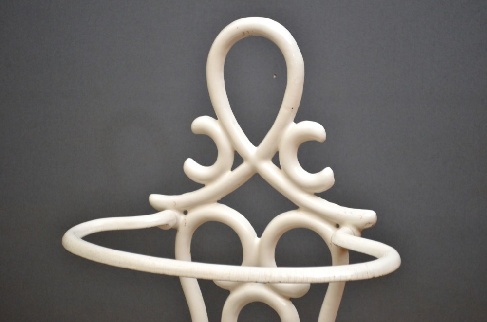A white enamelled cast iron Art Nouveau umbrella stand featuring fluid scrollwork motifs and an integrated base drip tray. View VI