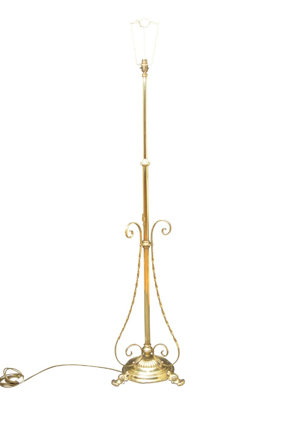 An antique Arts and Crafts brass standard floor lamp featuring a flared fabric shade, a height-adjustable central stem, scrollwork details, and a stepped circular base. View IX