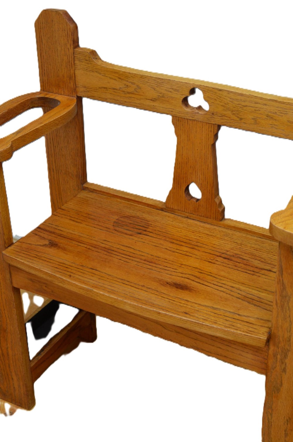A golden oak Arts and Crafts hall seat featuring a central backboard with a trefoil cut-out, flat armrests with circular stick apertures, and sturdy rectangular uprights. View III