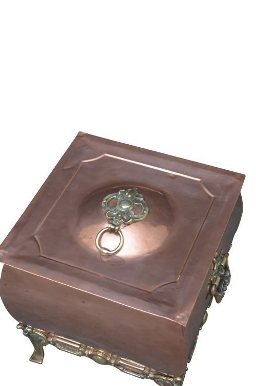 A late Victorian copper square vessel with rounded sides, ornate cast brass handles, decorative feet, and a fitted lid with a brass drop handle. View VII
