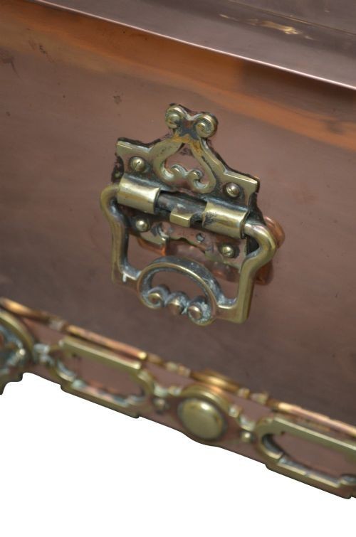 A late Victorian copper square vessel with rounded sides, ornate cast brass handles, decorative feet, and a fitted lid with a brass drop handle. View IX