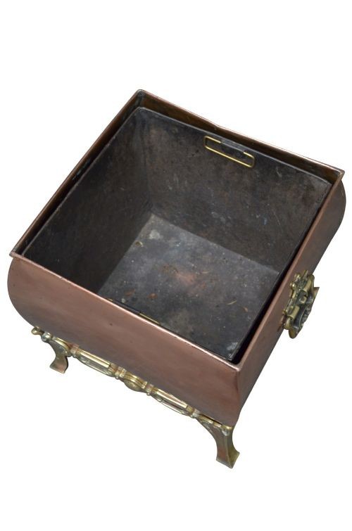 A late Victorian copper square vessel with rounded sides, ornate cast brass handles, decorative feet, and a fitted lid with a brass drop handle. View X