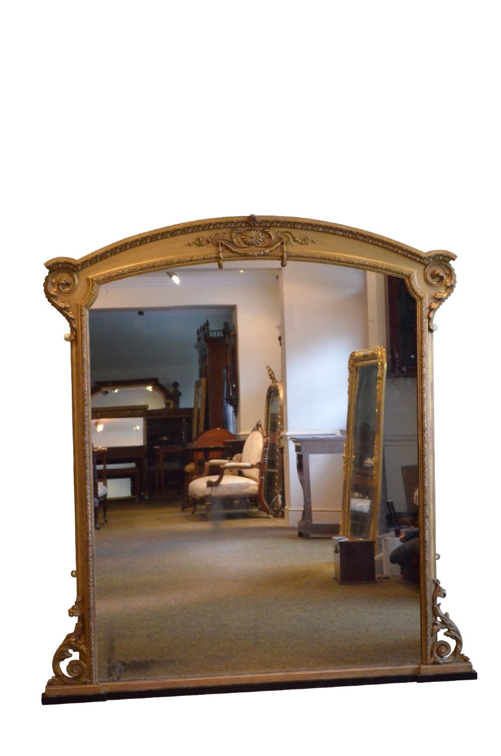 A large 19th-century English giltwood arched overmantel mirror featuring floral swag carvings at the crest and acanthus scroll feet at the base. View II