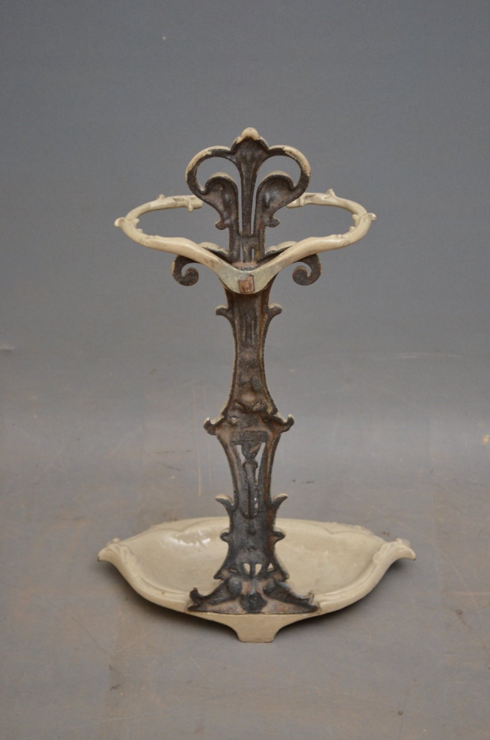 An Art Nouveau painted cream cast iron umbrella stand featuring organic scrollwork and an integrated drip tray at the base. View III