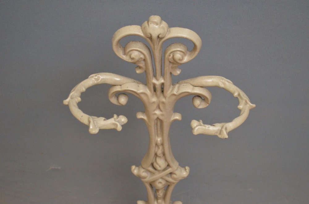 An Art Nouveau painted cream cast iron umbrella stand featuring organic scrollwork and an integrated drip tray at the base. View IV
