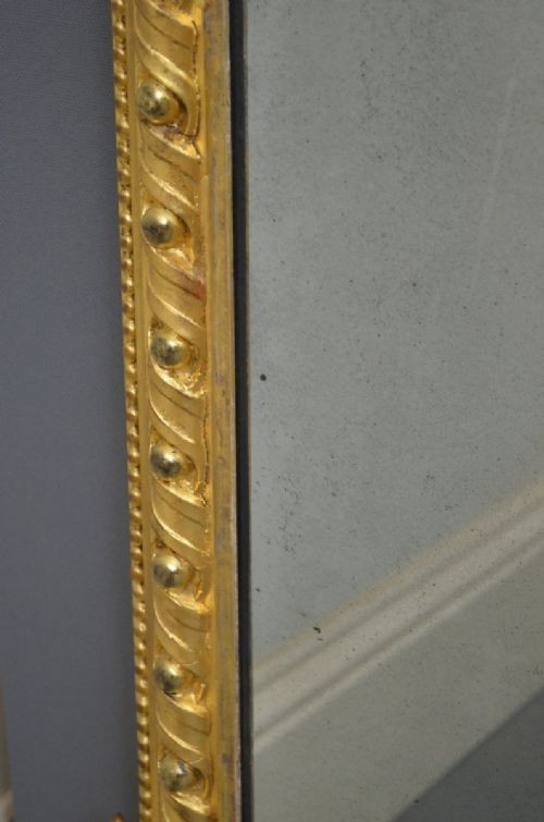 A rectangular Victorian giltwood overmantel mirror with carved rope twist moulding, corner scroll details, and original mirror glass. View VIII