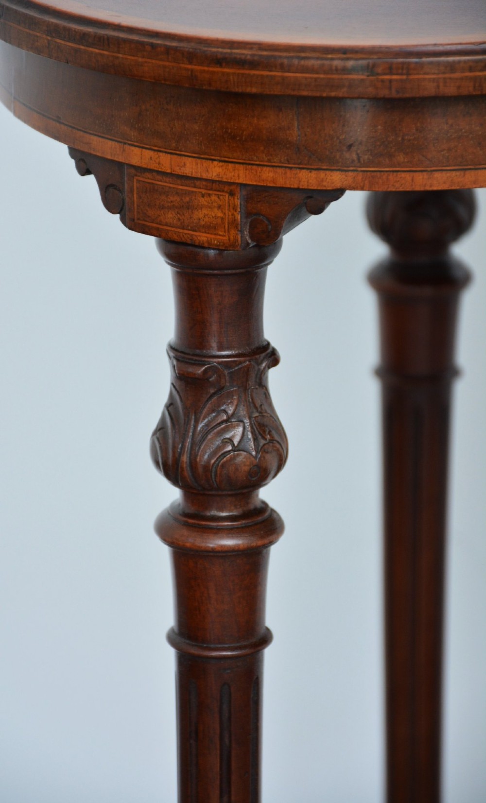 An Edwardian mahogany kidney-shaped side table featuring inlaid marquetry at the centre, fluted turned legs, a curved stretcher, and small brass castors. View VII