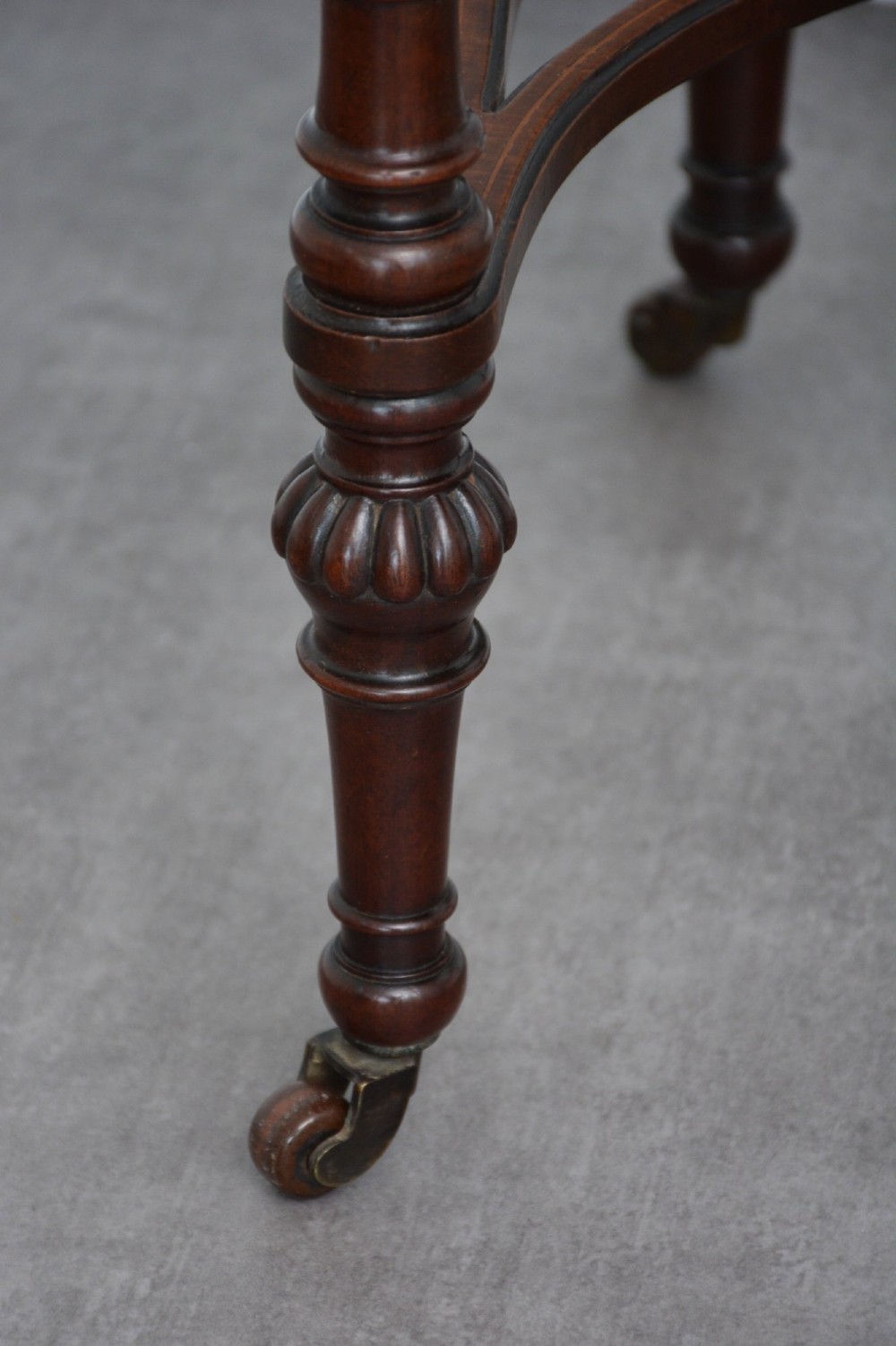 An Edwardian mahogany kidney-shaped side table featuring inlaid marquetry at the centre, fluted turned legs, a curved stretcher, and small brass castors. View VIII