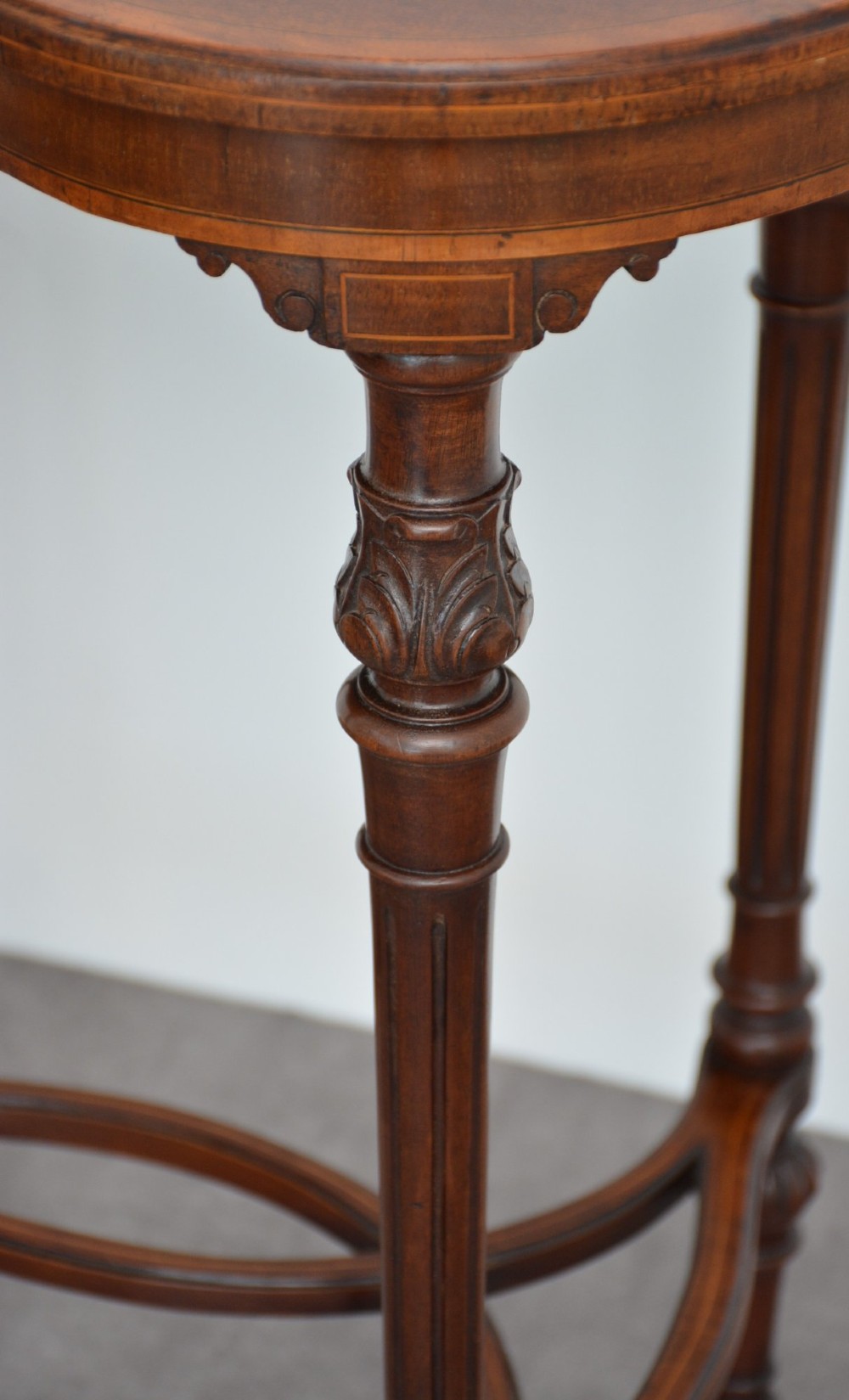 An Edwardian mahogany kidney-shaped side table featuring inlaid marquetry at the centre, fluted turned legs, a curved stretcher, and small brass castors. View X