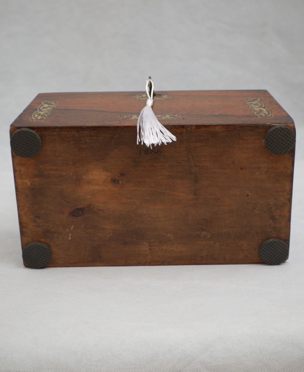 A Regency-era sarcophagus-shaped rosewood jewellery box featuring decorative scroll inlay and a key with a white tassel. View II